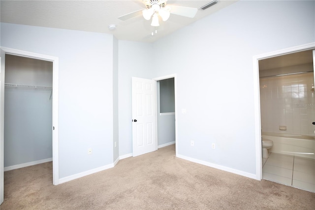 unfurnished bedroom featuring visible vents, a walk in closet, a closet, carpet, and baseboards