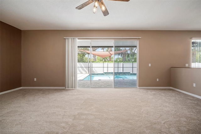 spare room with ceiling fan, baseboards, and carpet