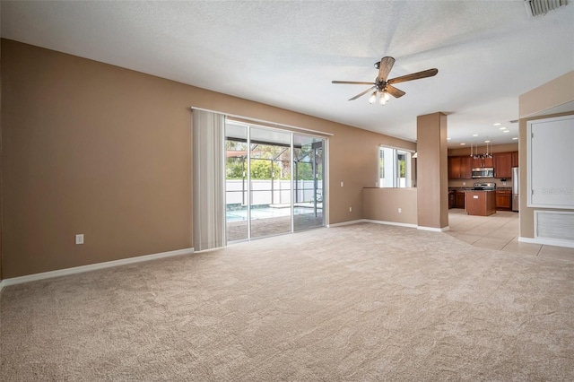 unfurnished living room featuring baseboards, ceiling fan, light carpet, and visible vents
