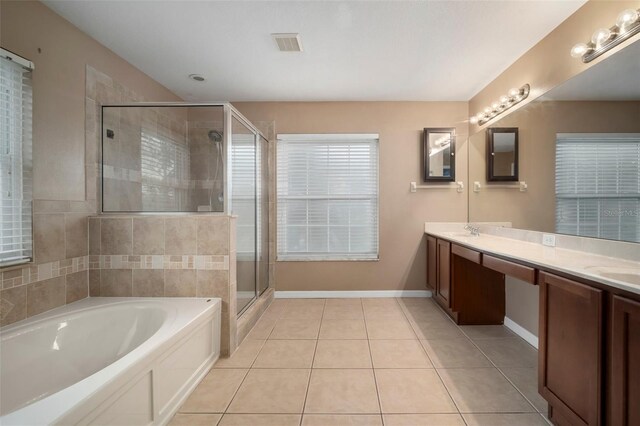 bathroom featuring double vanity, a bath, a shower stall, a sink, and tile patterned floors