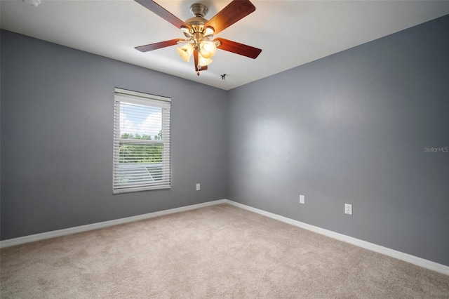 empty room featuring baseboards, a ceiling fan, and carpet flooring