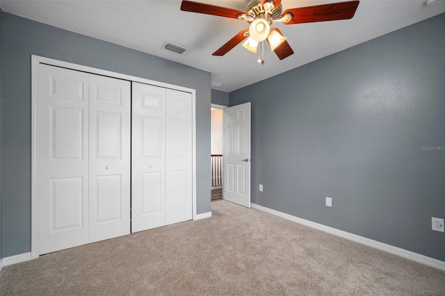 unfurnished bedroom with a closet, carpet, visible vents, a ceiling fan, and baseboards