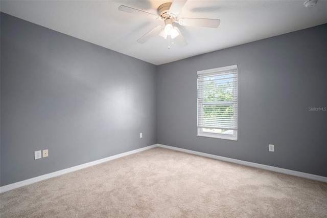 carpeted spare room with baseboards and ceiling fan