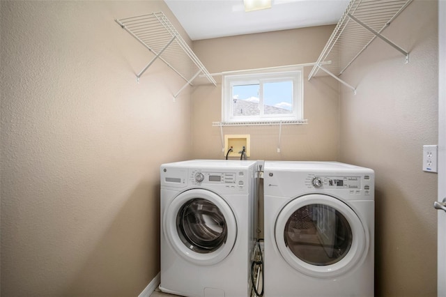 clothes washing area featuring laundry area and washer and clothes dryer