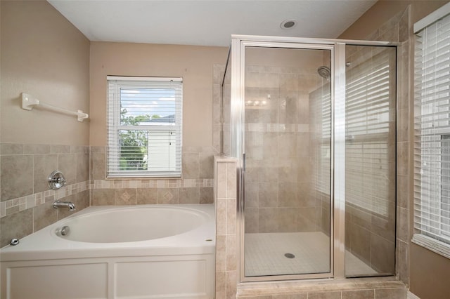 full bath featuring a stall shower and a bath