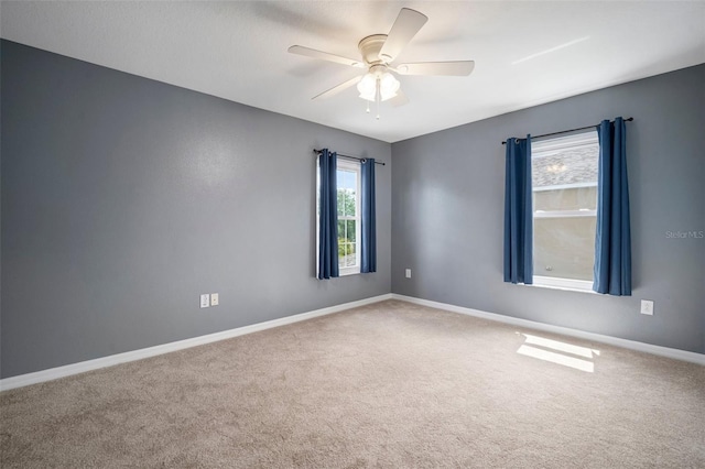 empty room featuring a ceiling fan, carpet flooring, and baseboards