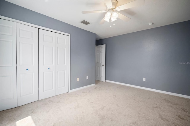 unfurnished bedroom with a closet, visible vents, ceiling fan, carpet flooring, and baseboards