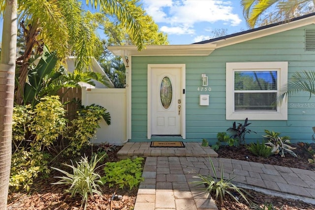 doorway to property featuring fence