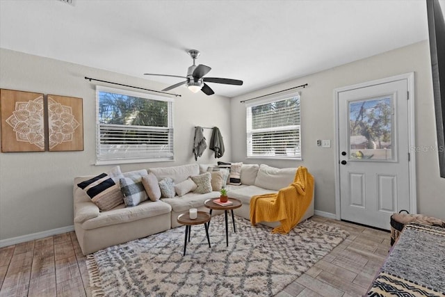 living room featuring baseboards, a ceiling fan, and wood finished floors