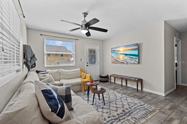 living room featuring wood finished floors, baseboards, and ceiling fan