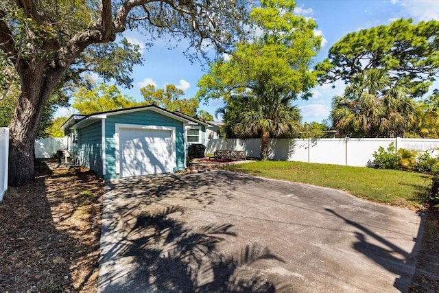 garage with driveway and fence