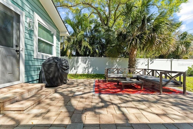 view of patio / terrace featuring grilling area, an outdoor living space, and a fenced backyard