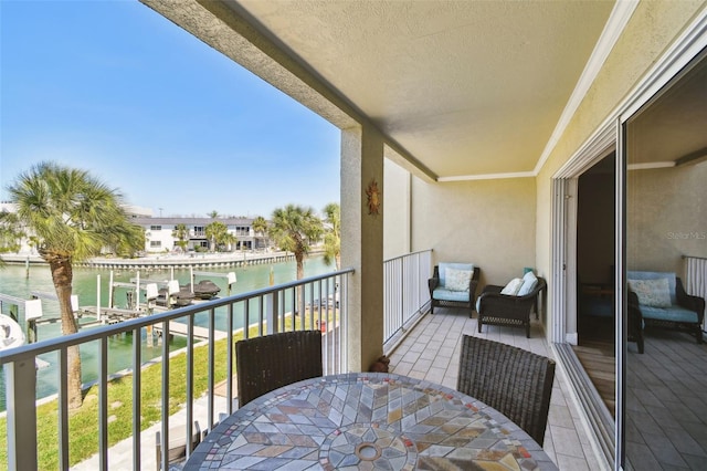 balcony featuring outdoor dining area and a water view