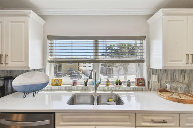 kitchen featuring ornamental molding, a sink, backsplash, stainless steel dishwasher, and light countertops