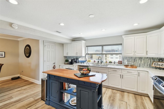 kitchen with white cabinetry, open shelves, wooden counters, and a sink