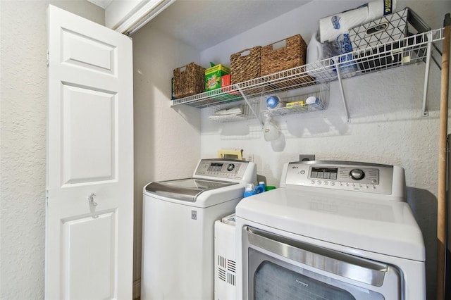 clothes washing area featuring independent washer and dryer and laundry area