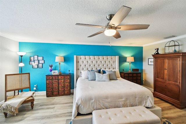 bedroom with crown molding, wood finished floors, and visible vents