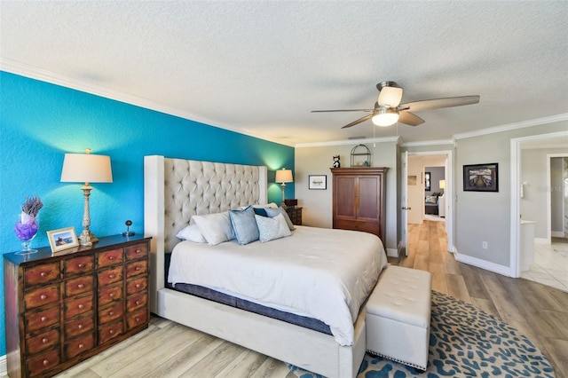 bedroom featuring baseboards, a textured ceiling, wood finished floors, and ornamental molding