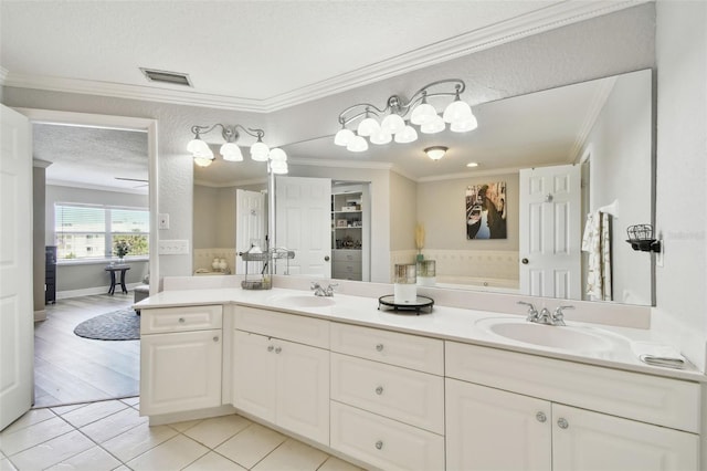 bathroom featuring a textured ceiling, double vanity, ornamental molding, and a sink