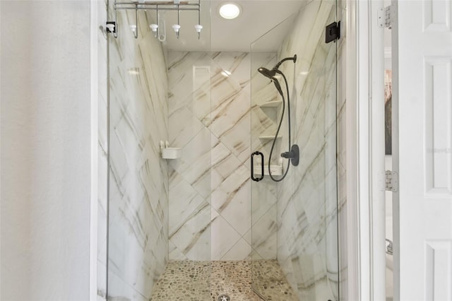 bathroom featuring a marble finish shower