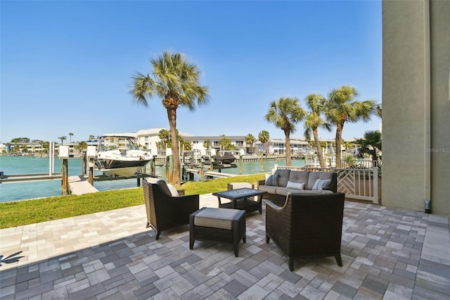 view of patio / terrace featuring boat lift, an outdoor hangout area, a dock, and a water view