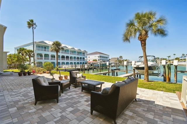 view of patio with a boat dock, an outdoor living space with a fire pit, a water view, and boat lift