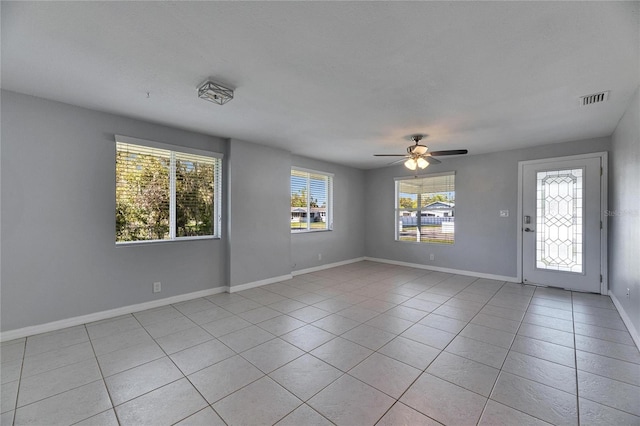 interior space featuring light tile patterned floors, visible vents, baseboards, and ceiling fan