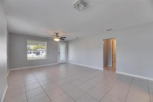 spare room with light tile patterned floors, baseboards, and a ceiling fan