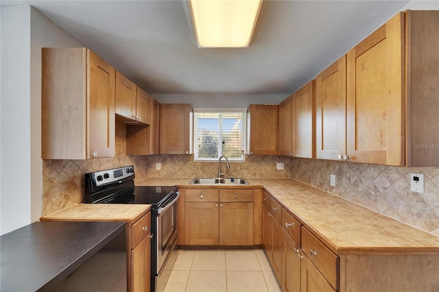 kitchen with a sink, backsplash, stainless steel electric stove, light tile patterned flooring, and light countertops