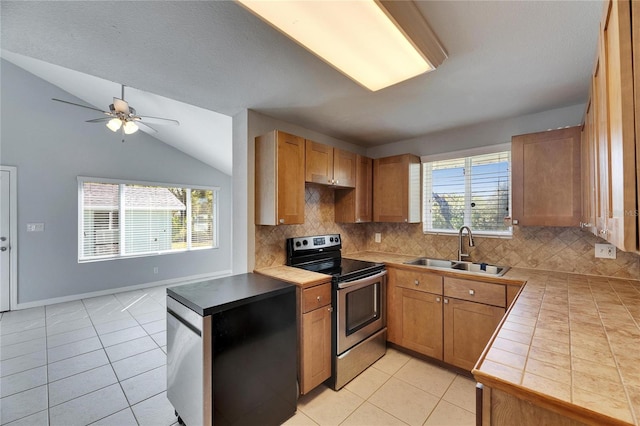 kitchen featuring light tile patterned flooring, electric range, ceiling fan, and a sink