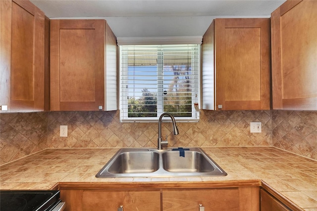 kitchen with backsplash, brown cabinets, and a sink