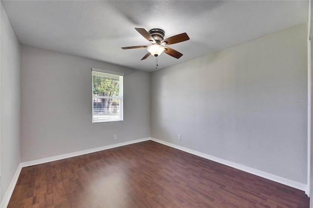 unfurnished room with a textured ceiling, a ceiling fan, baseboards, and dark wood-style flooring