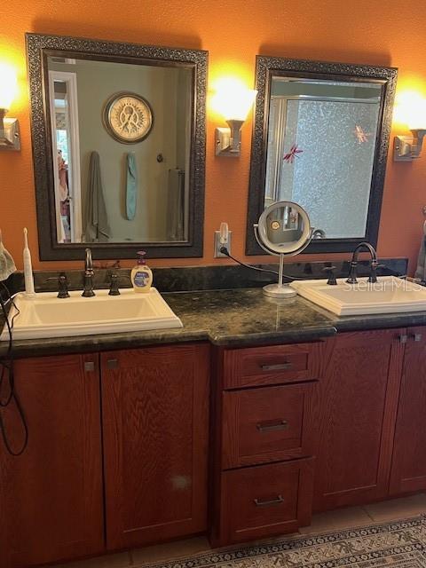 bathroom featuring double vanity, tile patterned floors, and a sink