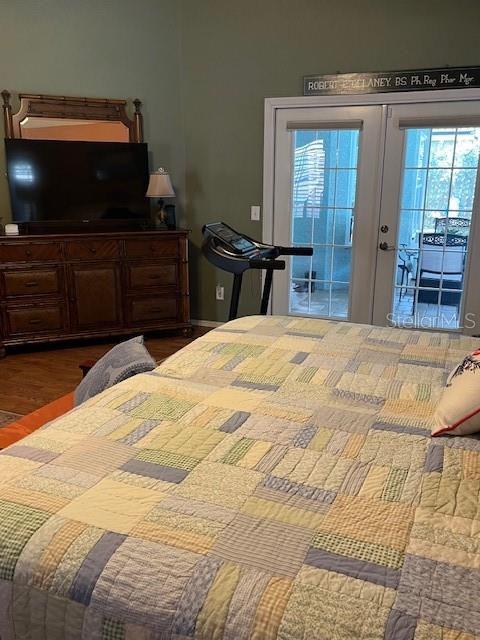 bedroom with french doors, wood finished floors, and access to exterior