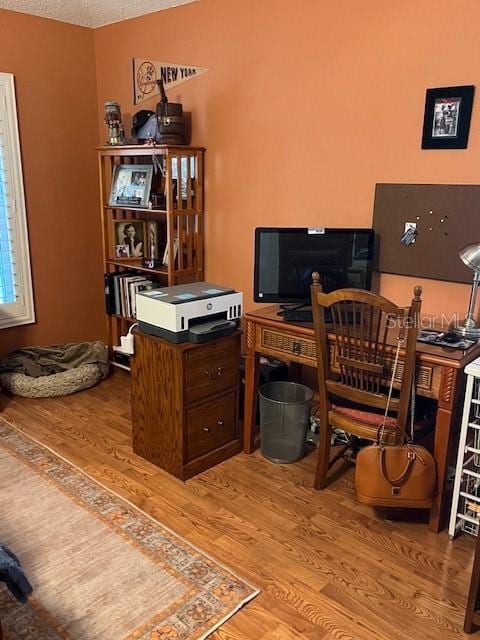 home office with a textured ceiling and wood finished floors