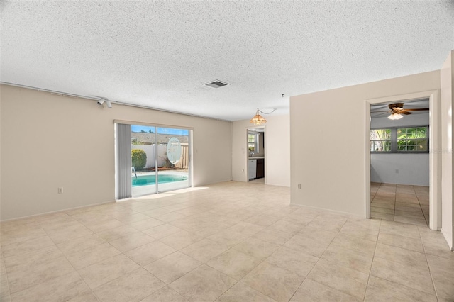 spare room with plenty of natural light, visible vents, and a textured ceiling