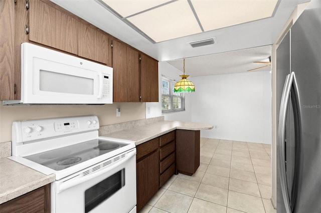 kitchen with visible vents, light countertops, light tile patterned floors, hanging light fixtures, and white appliances