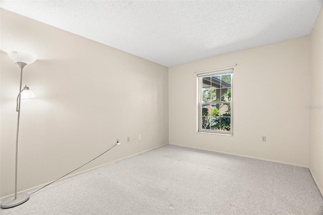 empty room with baseboards, carpet floors, and a textured ceiling