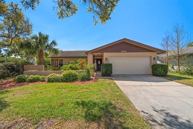 view of front of house with stucco siding, an attached garage, driveway, and a front lawn