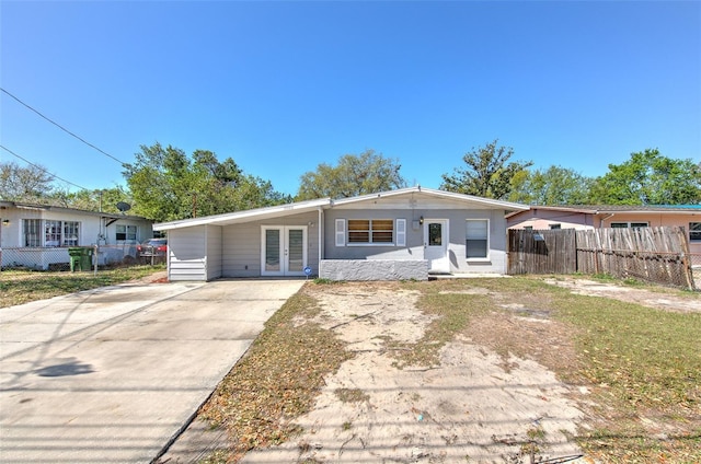 view of front of house featuring a carport, french doors, driveway, and fence