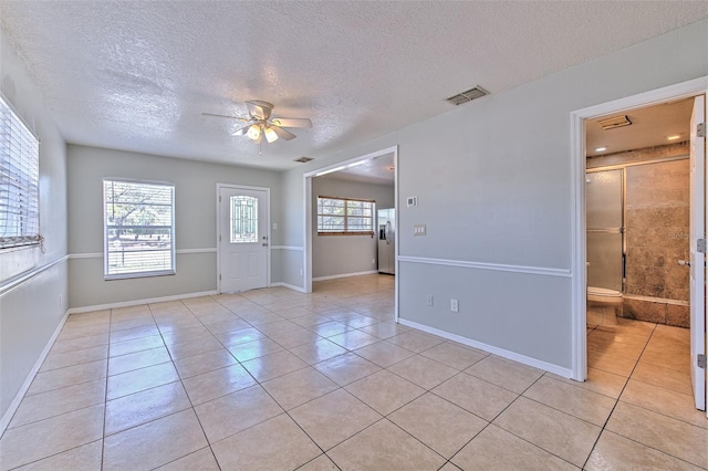 unfurnished room featuring light tile patterned floors, visible vents, baseboards, and ceiling fan