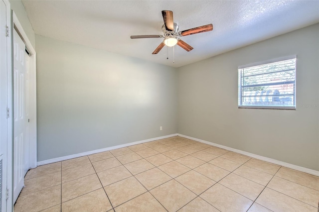 spare room with light tile patterned flooring, baseboards, and ceiling fan