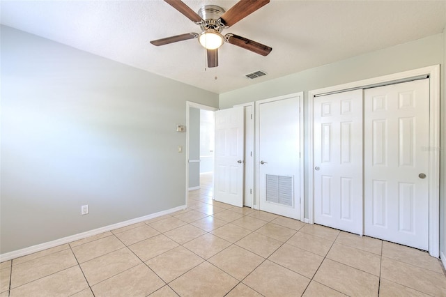 unfurnished bedroom featuring light tile patterned floors, visible vents, and baseboards