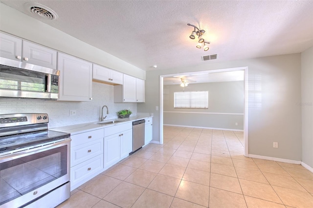 kitchen with visible vents, appliances with stainless steel finishes, light countertops, and a sink