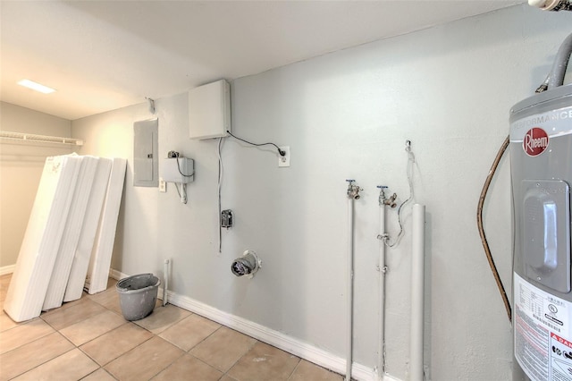 interior space with light tile patterned floors, baseboards, laundry area, electric panel, and water heater