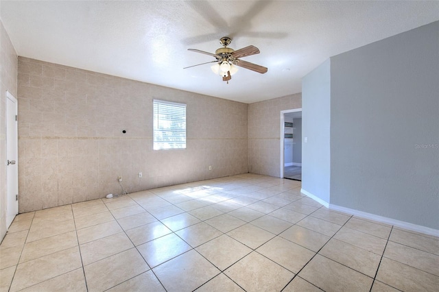 spare room featuring light tile patterned flooring and a ceiling fan