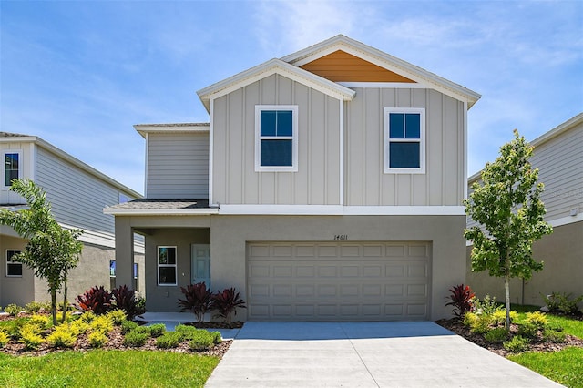 view of front of house with an attached garage, board and batten siding, driveway, and roof with shingles