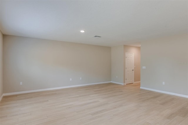 spare room featuring light wood finished floors, visible vents, recessed lighting, and baseboards