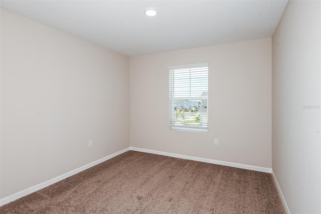 empty room with baseboards and carpet