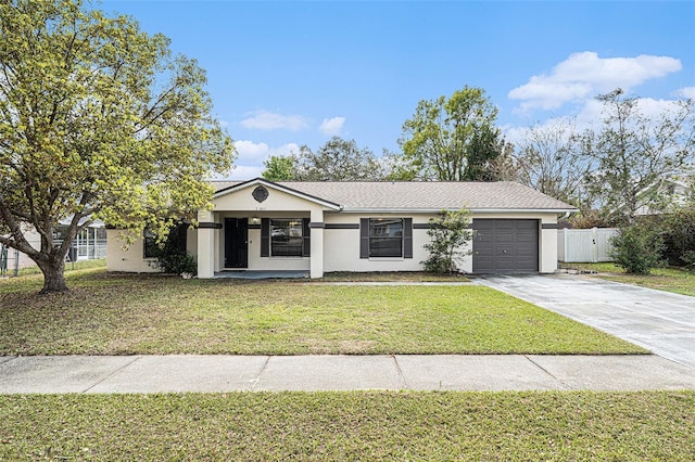 view of front of home featuring a front lawn, fence, stucco siding, driveway, and an attached garage